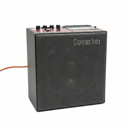 Black audio amplifier on a gray concrete floor