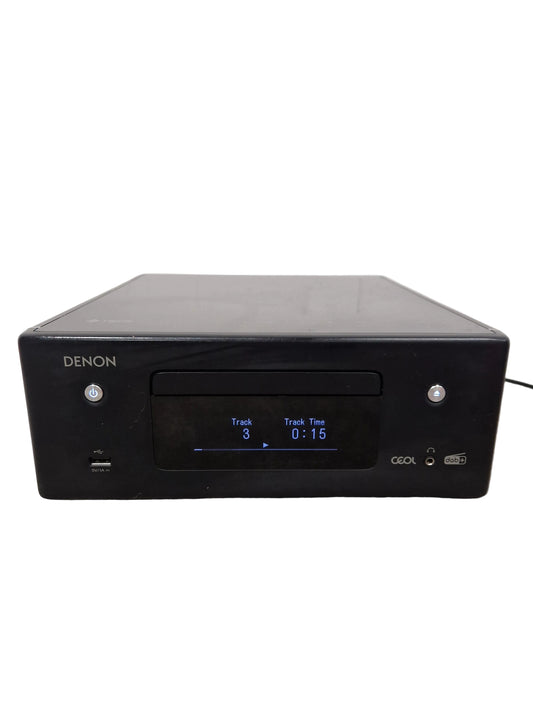 Black Denon audio component on a gray surface