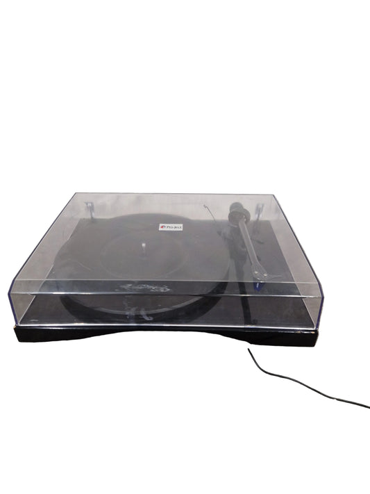 Black electronic device with clear cover attached to a textured wall.